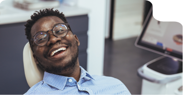 Senior woman in dental chair grinning at her dentist